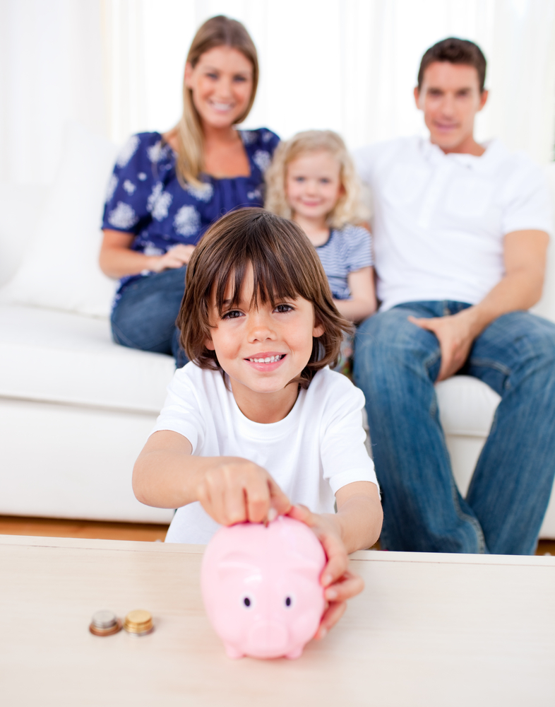Family with a kid putting money into her piggy bank