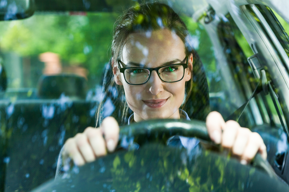 woman in business attire driving in her vehicle